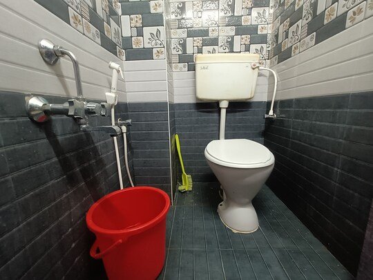 Tiled attached bathroom with shower and western toilet